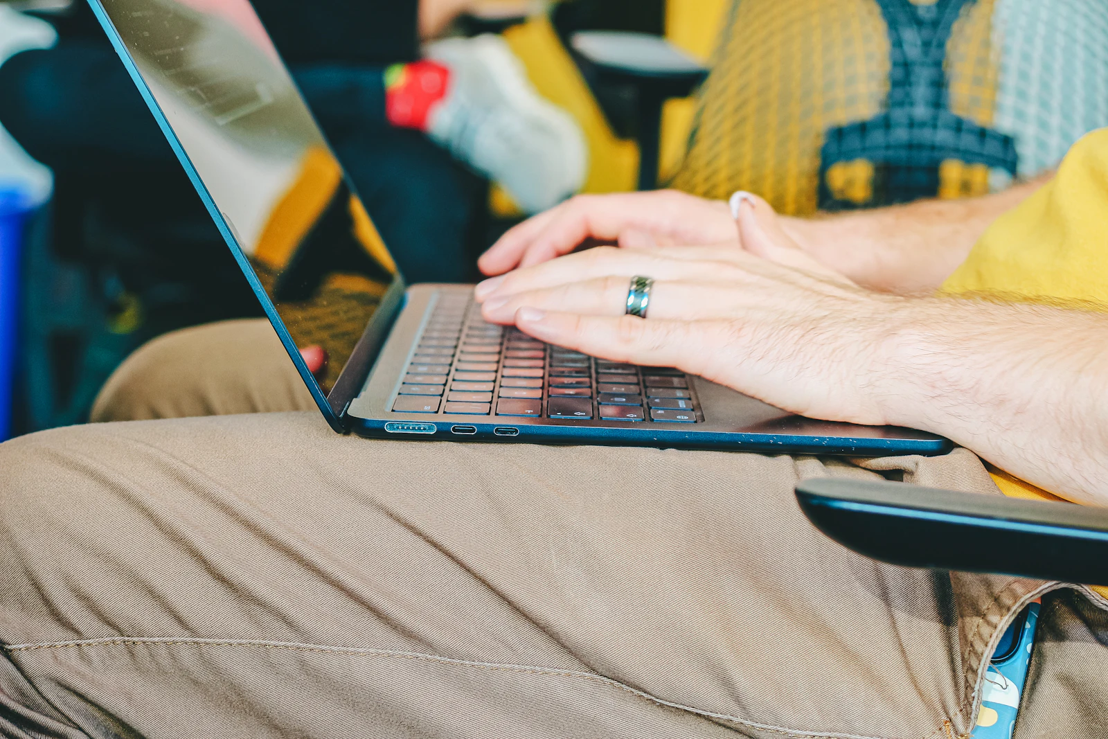 Mains portant une bague, tapant sur le clavier d'un ordinateur portable